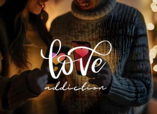 A close-up of a couple standing together, each holding a smartphone with a heart on the screen. Their body language speaks volumes, illuminated by warm, cozy lighting against a blurred backdrop of festive lights. The text "love addiction" is prominently displayed in the center.