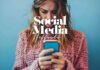 A woman with long hair wearing a pink knitted sweater is looking intently at her smartphone against a blue background. Overlaid text reads "Negative Effects of Social Media," highlighting the potential impact of social media use.