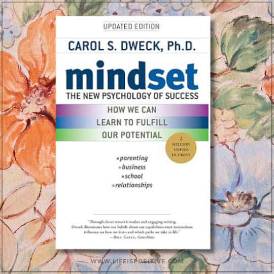 The image depicts the updated cover of "Mindset: The New Psychology of Success by Carol S. Dweck, Ph.D." against a white backdrop with blue and black text. A gold circle proudly announces "2 million copies in print," while a floral design with large, colorful blooms graces the background.