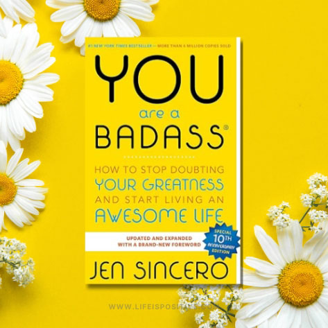 The image displays "You Are a Badass" by Jen Sincero against a vibrant yellow backdrop. White daisies with yellow centers surround the book, which champions self-empowerment. This special 10th anniversary edition inspires readers to embrace living an awesome life. #youarebadass.